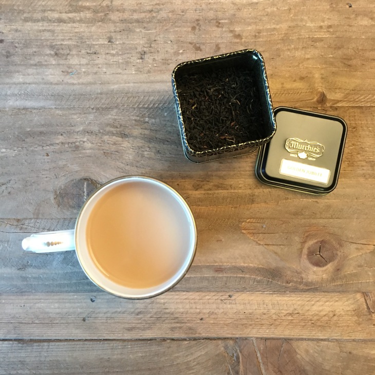 Cup of tea and loose leaf tea on a wooden table